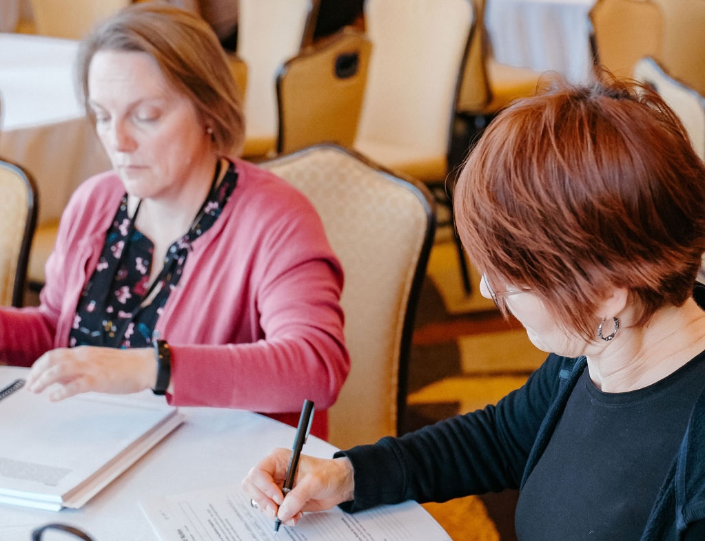 2 educators woking on a workbook together