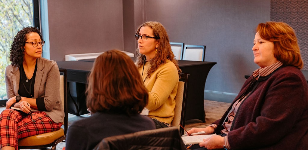 Four adults talking in a circle